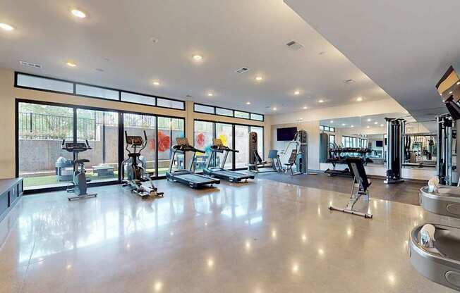 A spacious gym with a variety of equipment and a large mirror on the wall.