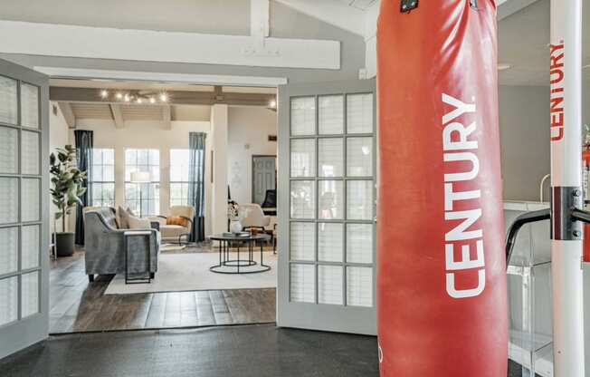 a gym with a red punching bag in front of a living room