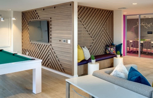 A room with a pool table and a couch.