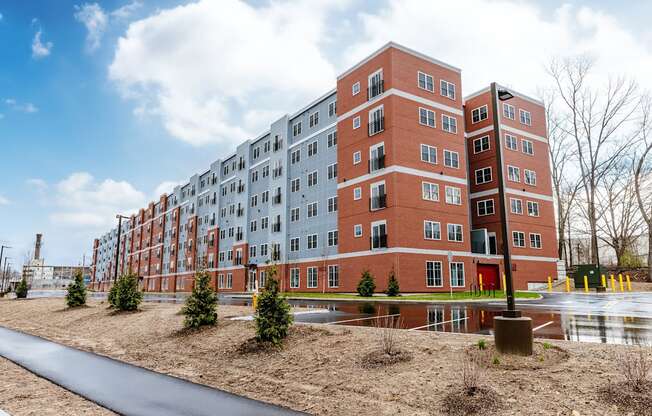 A large red brick building with a paved walkway in front.
