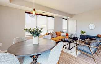 a dining room and living room with a yellow couch and blue chairs
