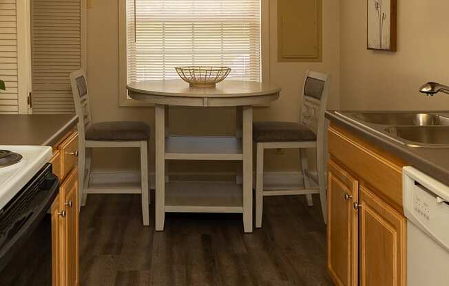 A kitchen with a table and chairs in the middle.