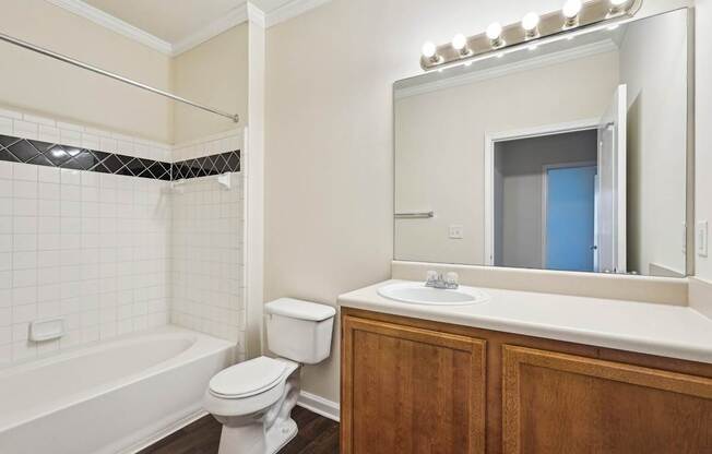 A bathroom with a white toilet, sink, and shower tub