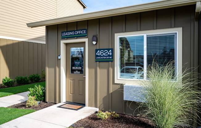 the front of a building with a door and a sign that reads lease office