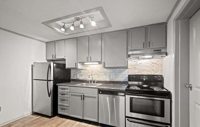 Retreat at Indian Lake Hendersonville TN apartments modern kitchen with stainless steel appliances and wooden flooring.