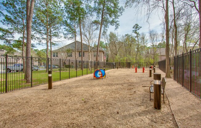 View of Fenced-In Dog Park with Agility Course and Landscaping at Raveneaux Apartments