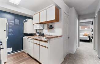 a kitchen with white cabinets and a sink and a refrigerator