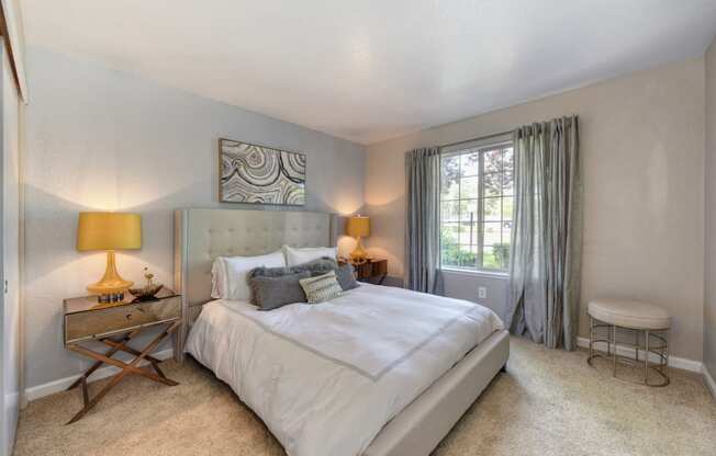 Bedroom with Window and Blue Curtains, Carpet, and Lamps,