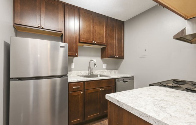 St. Louis Park, MN Courtyard Apartments. A kitchen with wooden cabinets and a stainless steel refrigerator