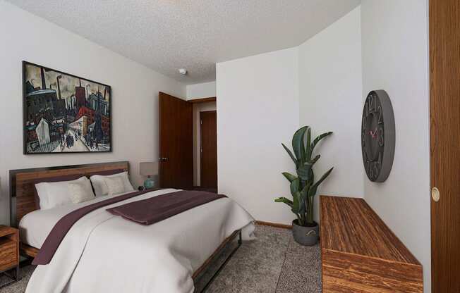 Bedroom with a bed and a potted plant at Park Place Apartments in Fargo, ND