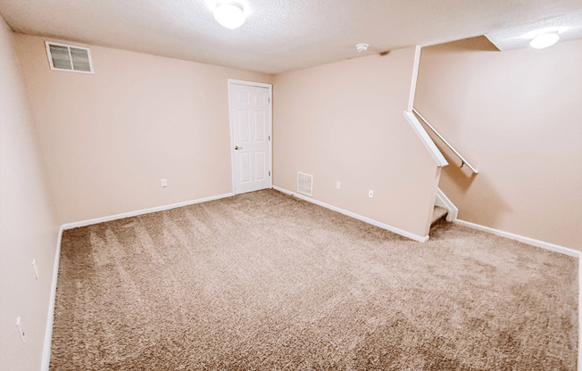 an empty room with carpeted floors and a white door