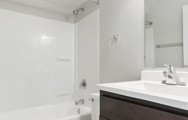 A white toilet sits in a bathroom next to a sink.