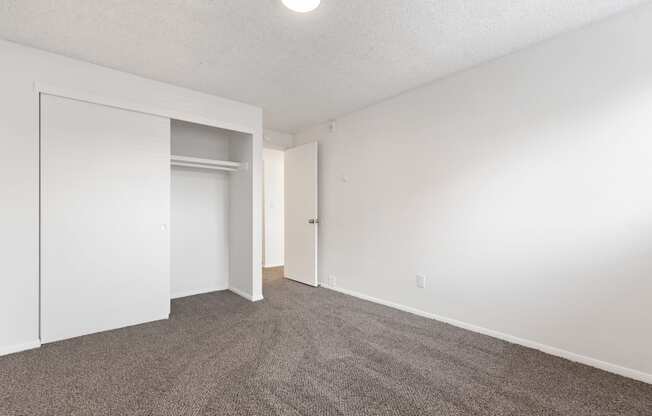 an empty living room with carpet and white walls