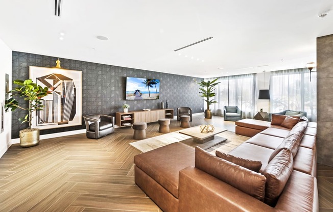 a living room with a large brown couch and a flat screen tv on the wall