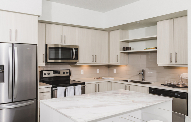 Stunning kitchens with french door stainless steel refrigerators, quartz counters, tile backsplash, and built in shelving