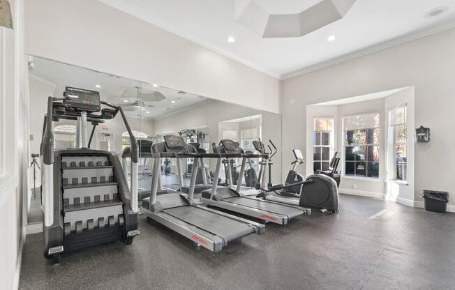 a gym with treadmills and other exercise equipment in a large room