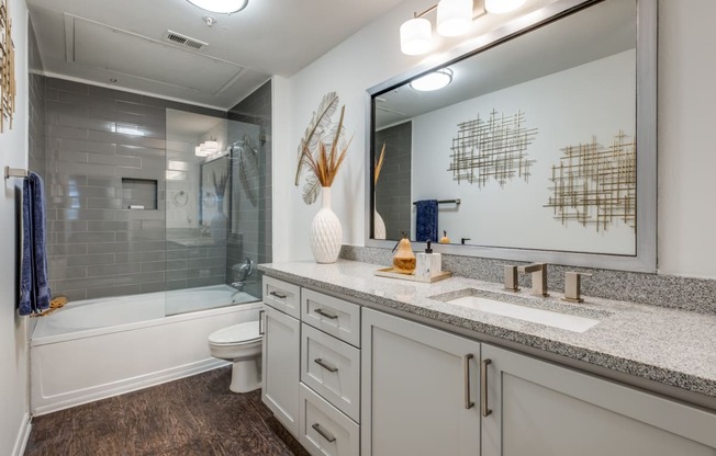 a bathroom with a large mirror and a shower and a sink