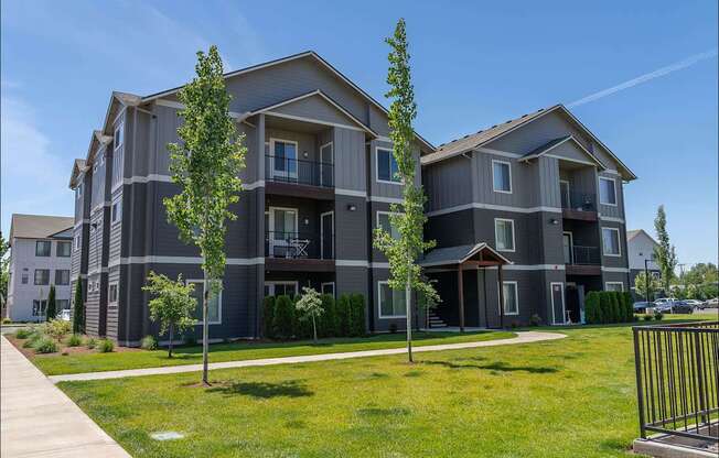 A modern apartment building with a well-maintained lawn in front at Northplace Apartment Homes, Salem, OR