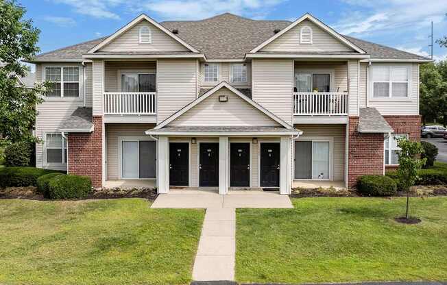 the front of a house with a sidewalk in front of it