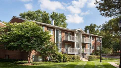 an apartment building with a tree in front of it