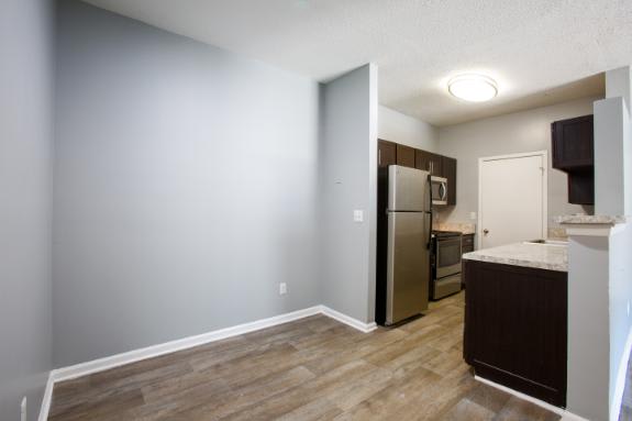 A kitchen area with a refrigerator, microwave, and oven.