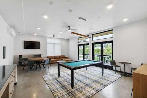 A room with a pool table and a television.