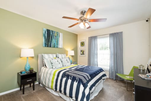 a bedroom with a large bed and a ceiling fan  at Lake Johnson Mews, Raleigh, 27606
