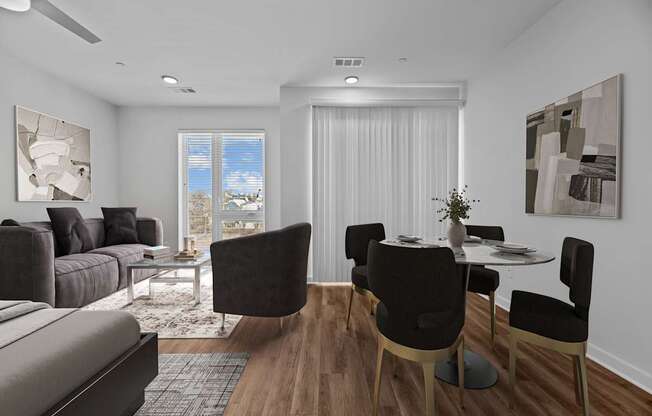 A modern living room with a grey sofa, a coffee table, and a dining table set up.