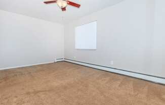 a bedroom with white walls and a ceiling fan