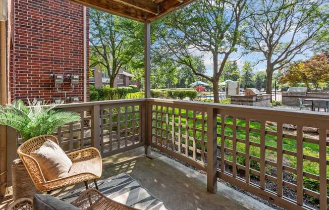 A wooden chair with a cushion is on a wooden deck.
