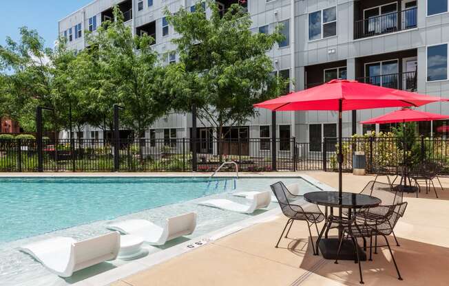 our apartments have a large pool and patio with chairs and umbrellas at Grand Flats, St. Louis, MO, 63104