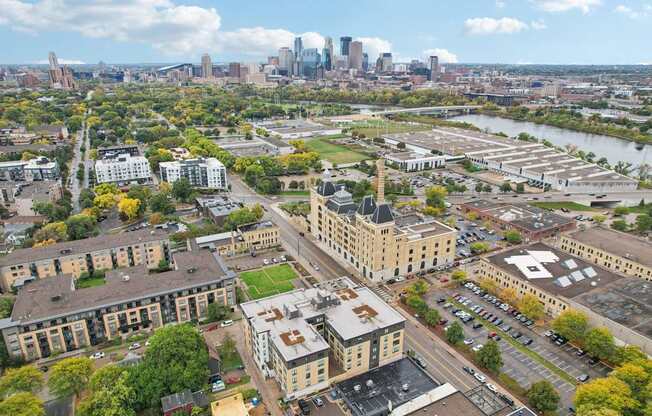 A cityscape with buildings and a river in the foreground.