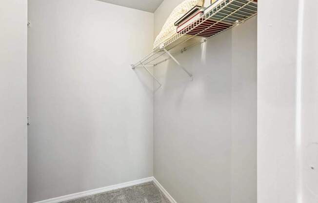 A white closet with a shelf and a fan.