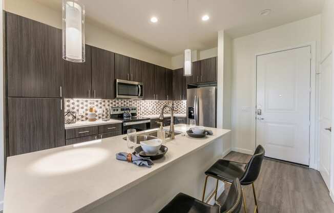 a renovated kitchen with white cabinets and a stainless steel refrigerator at Residences at 3000 Bardin Road, Texas