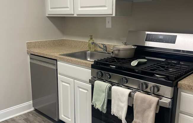 A kitchen with white cabinets and a black stove top oven.
