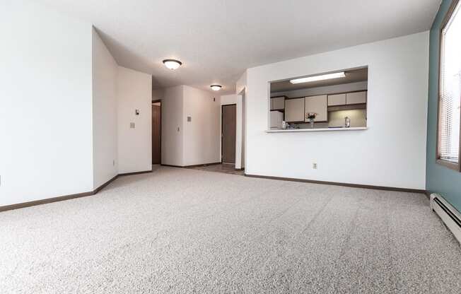 Grand Forks Primrose Apartments. An empty living room with a kitchen in the background