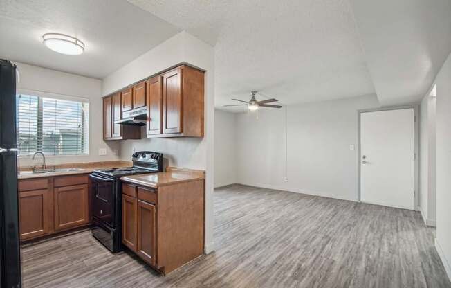 an empty kitchen and living room with a ceiling fan