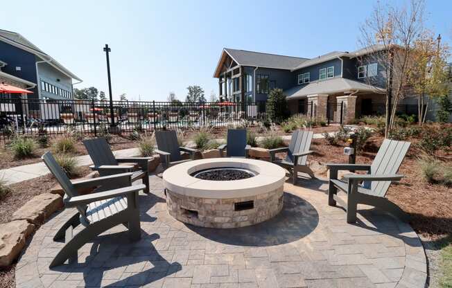 an outdoor fire pit with chairs and a house in the background at The Crest at Acworth, Acworth, GA, 30102