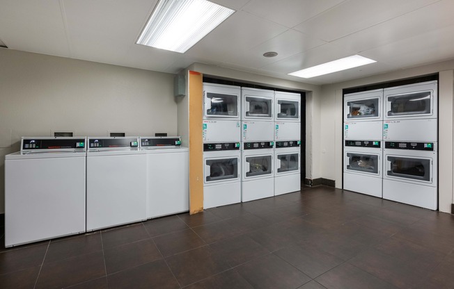 a laundry room with several washes and dryers in it