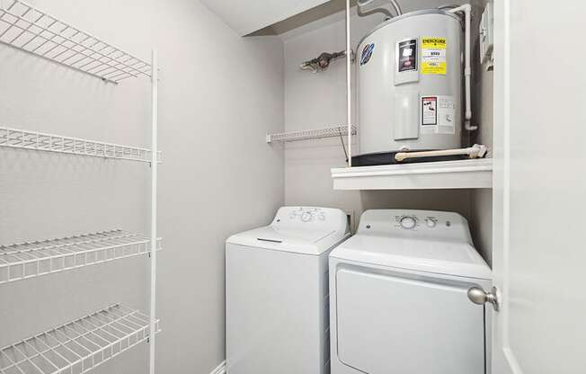 Model Laundry Room with Wood-Style Flooring, Water Heater & Storage Shelves at Allure North Dallas Apartments located in Dallas, TX.