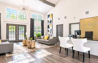 A modern living room with a grey sofa, a white chair, and a wooden coffee table.