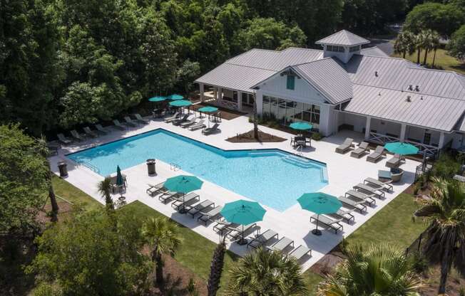 arial view of a resort style pool with lounge chairs and umbrellas