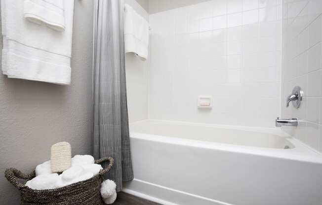 a bathroom with a bathtub and a basket of towels