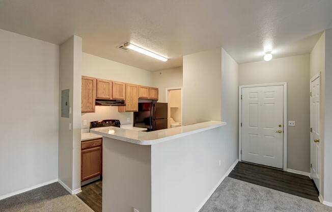 an open kitchen with a counter top and a door to a living room