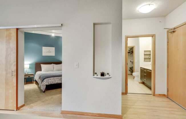 a bedroom with a bed and a bathroom with a mirror