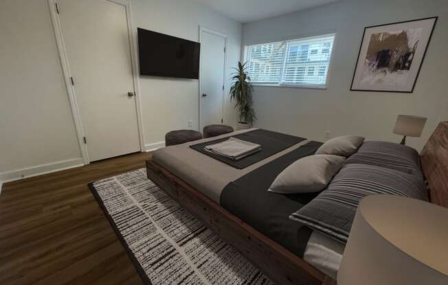 a bedroom with a bed and a tv on the wall at The Courts Midtown, Memphis, TN, 38104