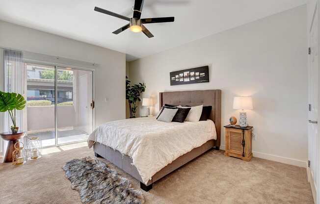 A bedroom with a large bed and a ceiling fan.