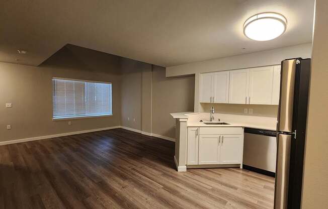 A kitchen with white cabinets and a black refrigerator.