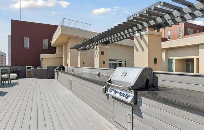 A grill is on a wooden deck.