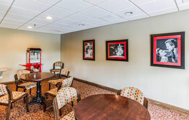 a conference room with tables and chairs and pictures on the wall